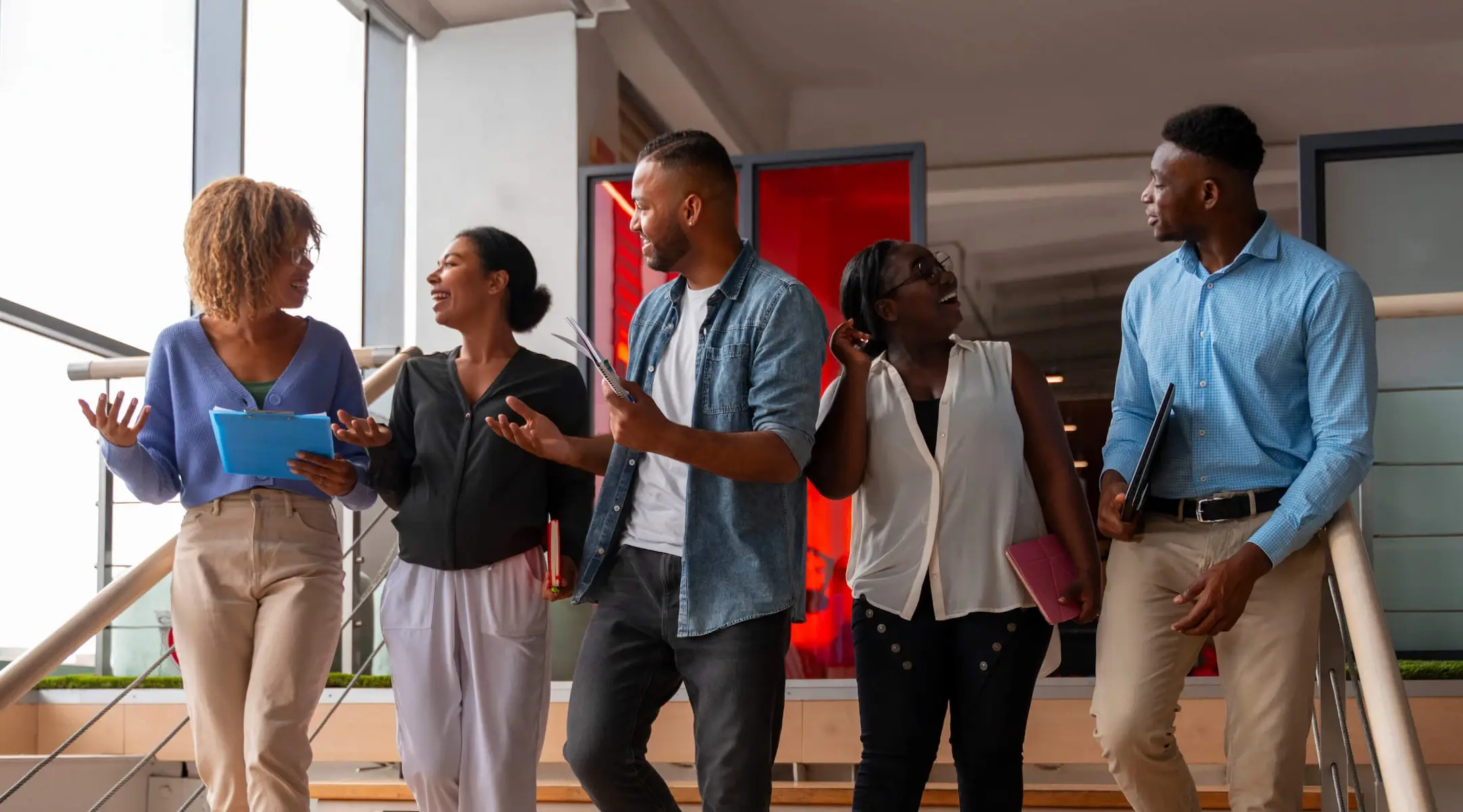 Four people in business casual discussing affiliate opportunities, promoting the Deriv Partner program.