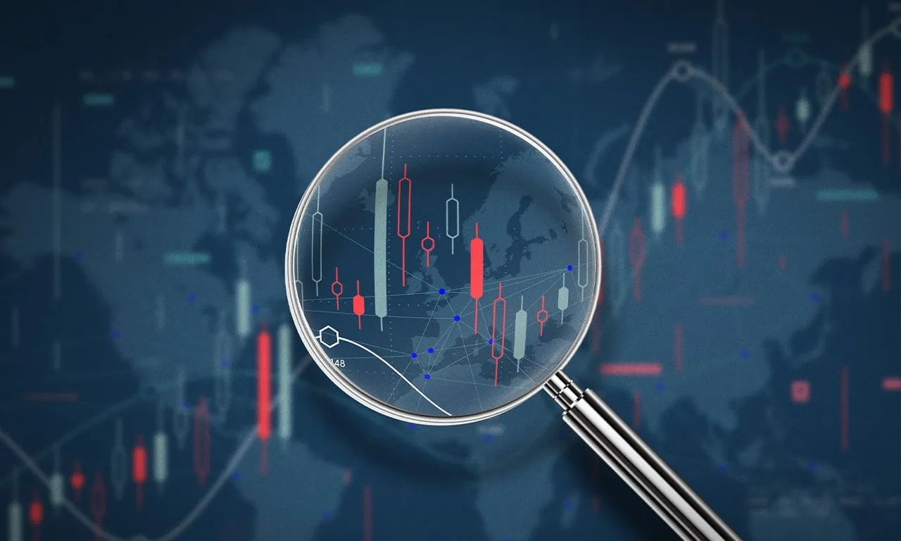 A magnifying glass highlights candlestick charts, showing the focus needed to spot trading opportunities.