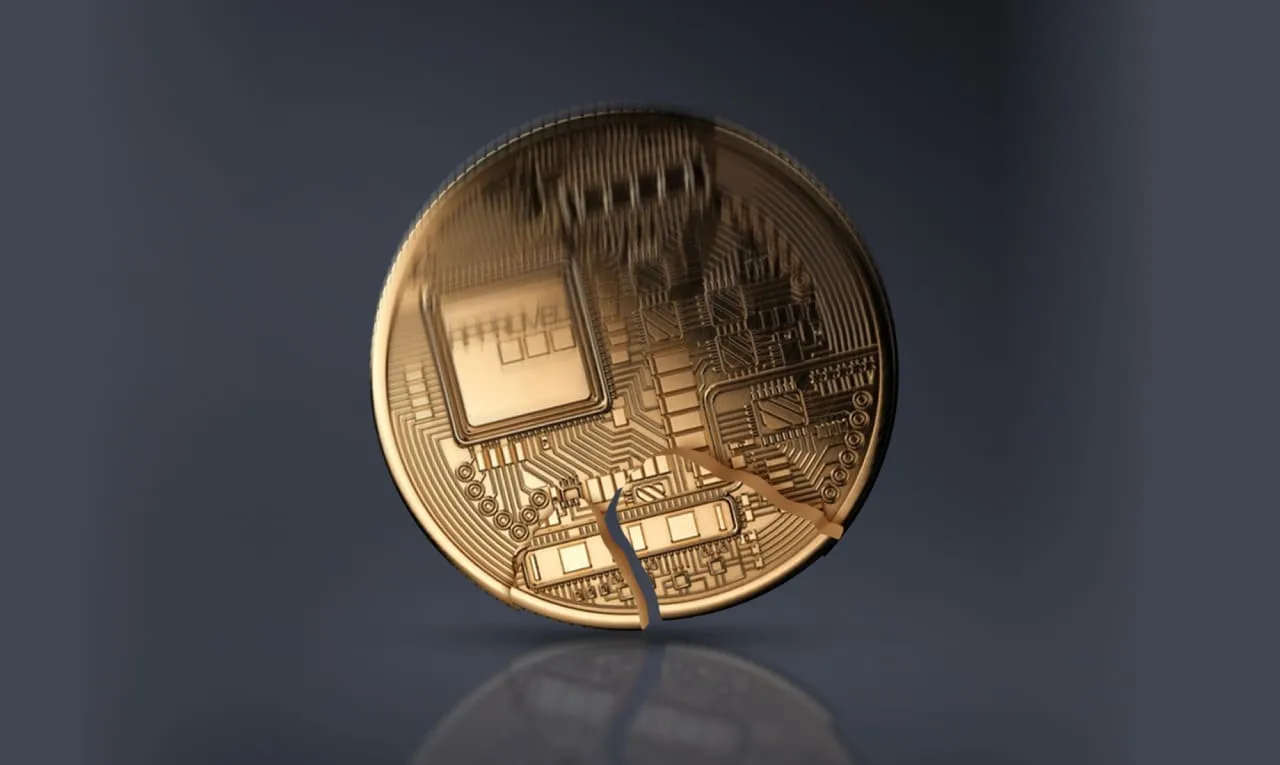 어두운 표면에 갈라진 디지털 코인으로, 암호화폐 불안정성 또는 시장 취약성을 상징합니다.