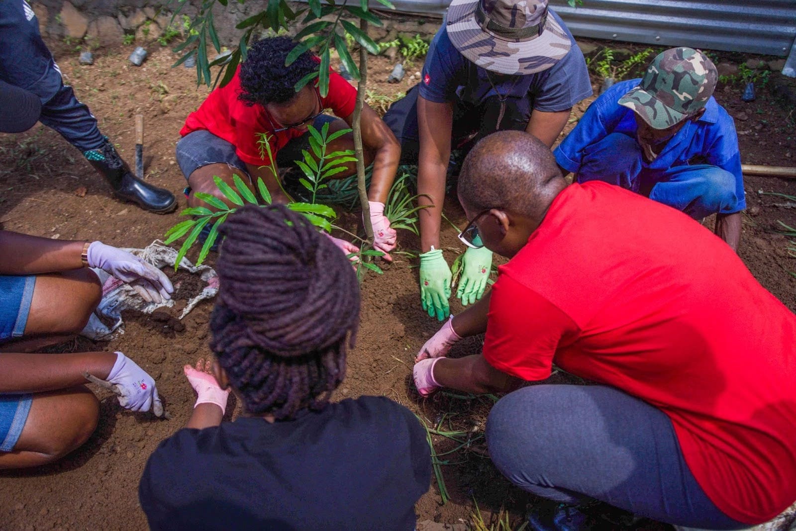 Deriv Rwanda volunteers join the community in planting trees for the memorial garden