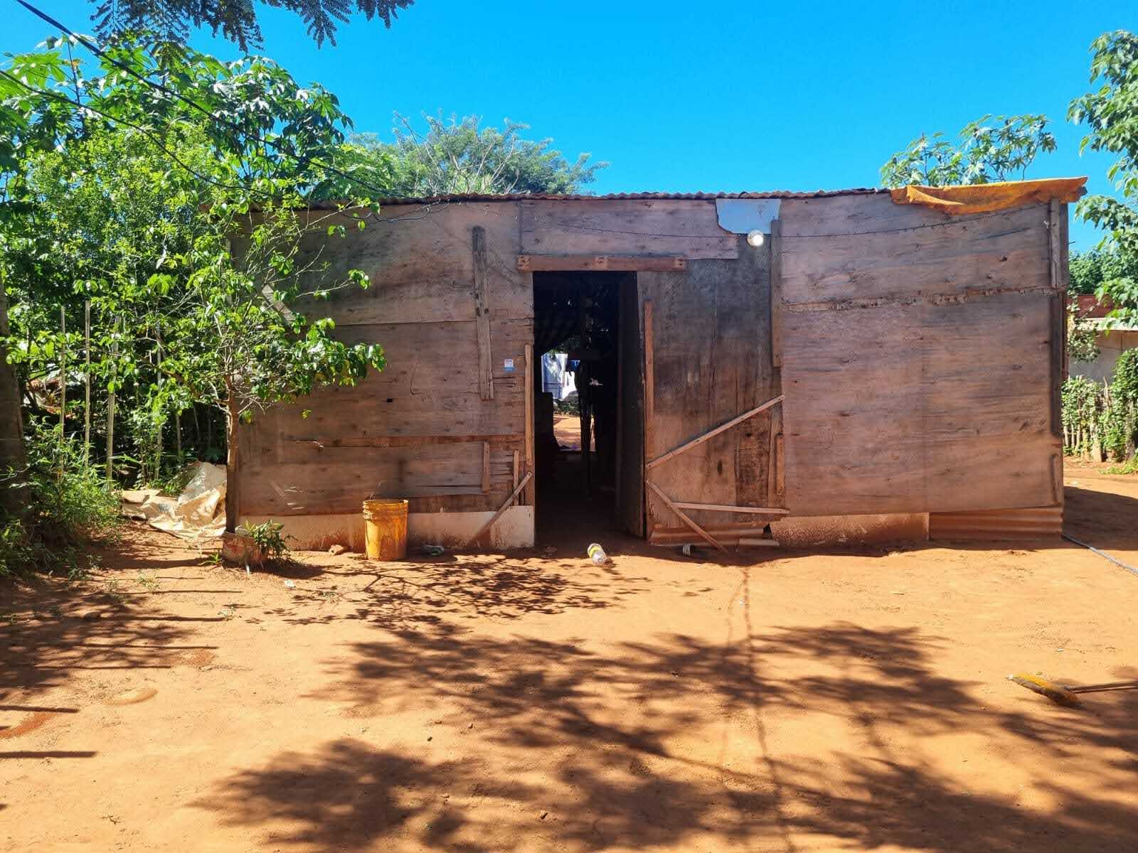 A house made of plywood and tarpaulin.