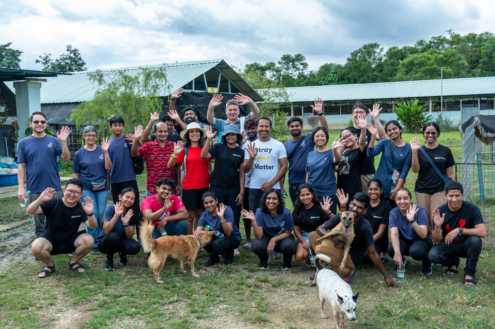 Deriv employees at the Malaysia Independent Animal Rescue (MIAR) with dogs, supporting animal welfare.