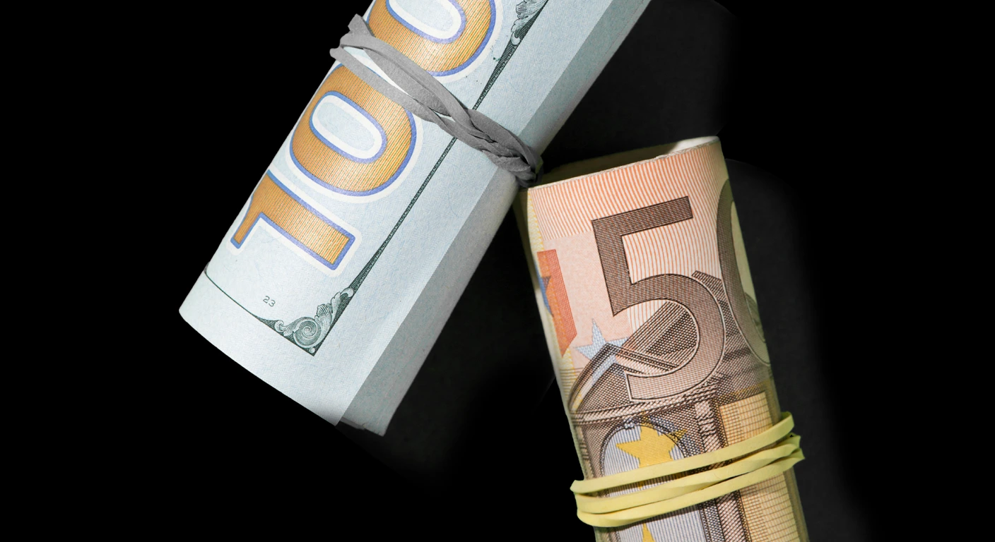 Tranches de dollars et d'euros américaines tenues par des élastiques, symbolisant la comparaison de devises ou les dynamiques financières mondiales. billets de banque en dollars et en euros tenus par des élastiques, symbolisant la comparaison des devises ou les dynamiques financières mondiales.