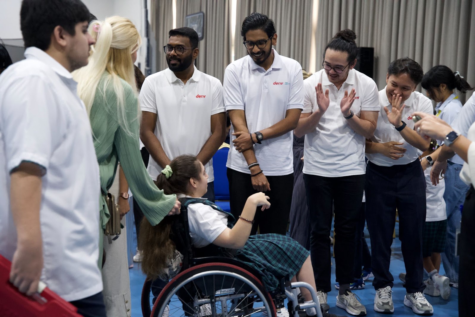 Deriv volunteers warmly applaud and chat with a student from DCSN .